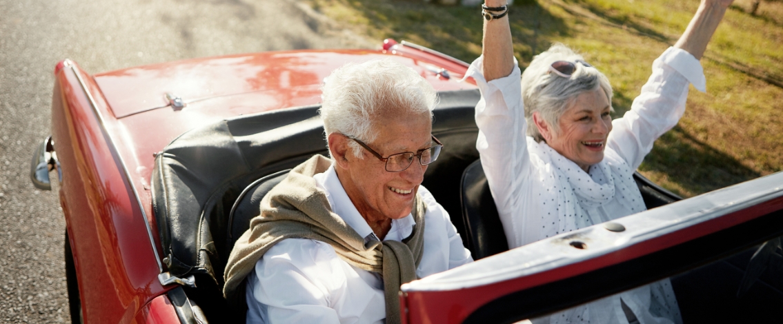 Older couple driving in a convertible A symbol of freedom, adventure, or enjoyment of life in later years.